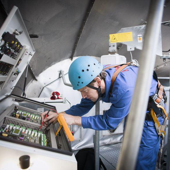 Mężczyzna w kasku sprawdzający elektrykę